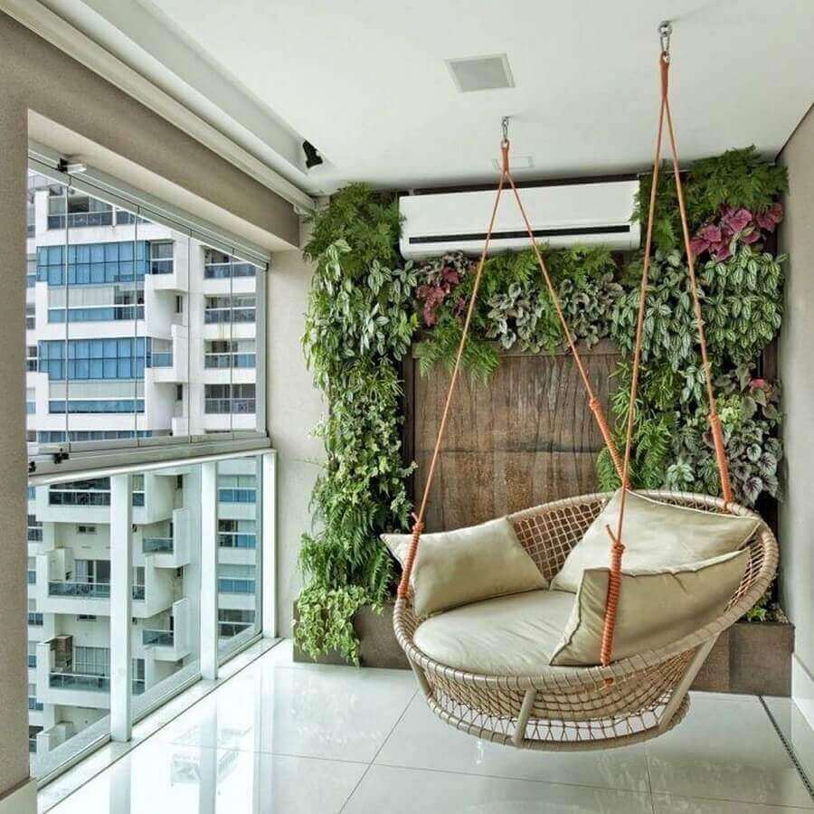 Cadeira de balanço com jardim vertical em varanda fechada